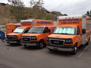 Water Damage Restoration Vans And Trucks At Job Site